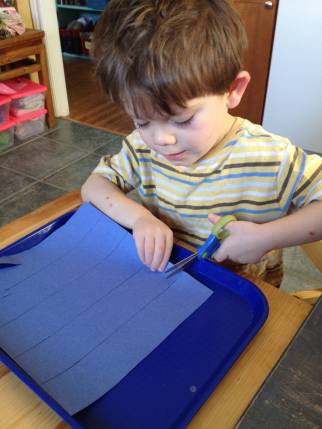 kid cutting chain paper